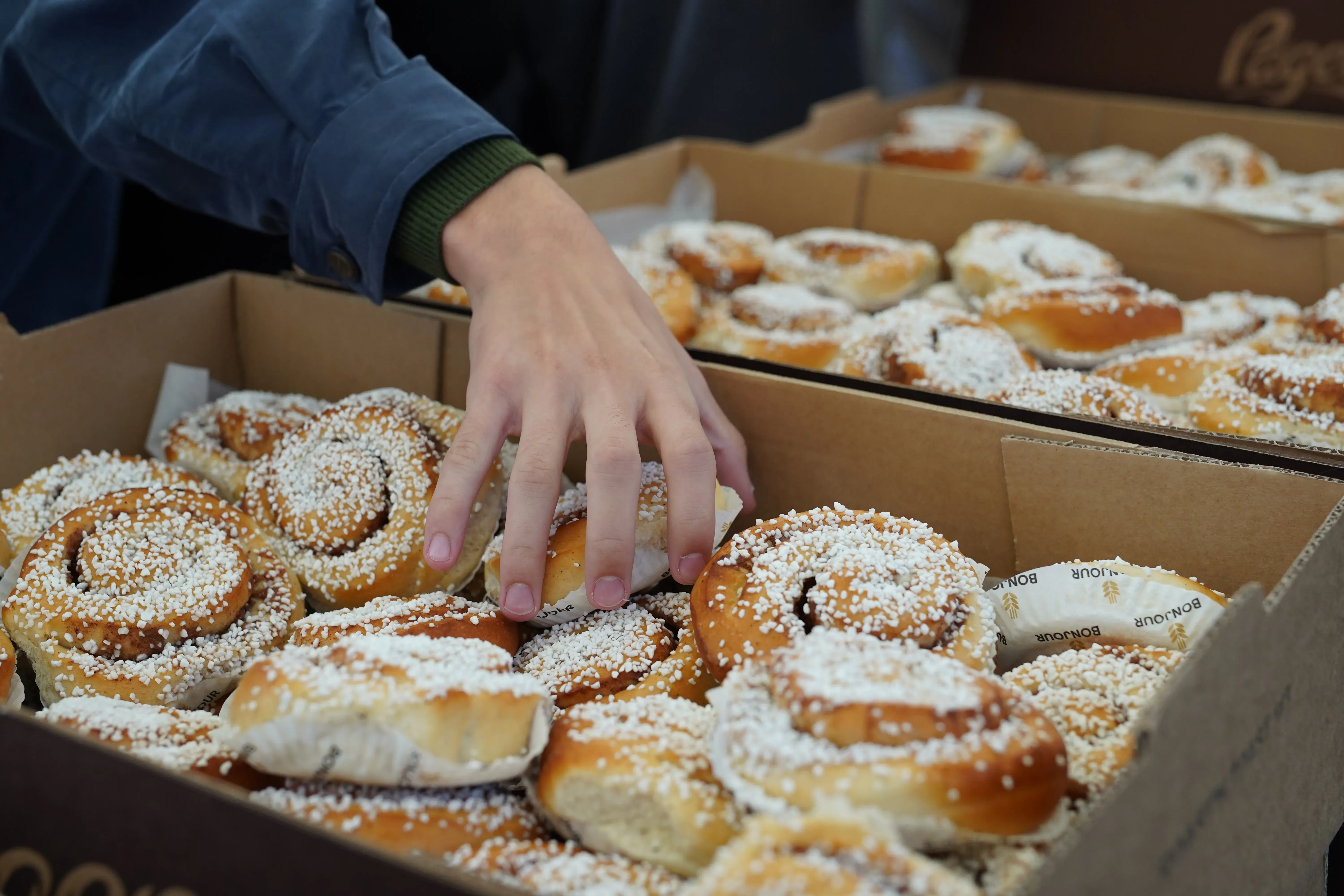 Hand som tar en kanelbulle