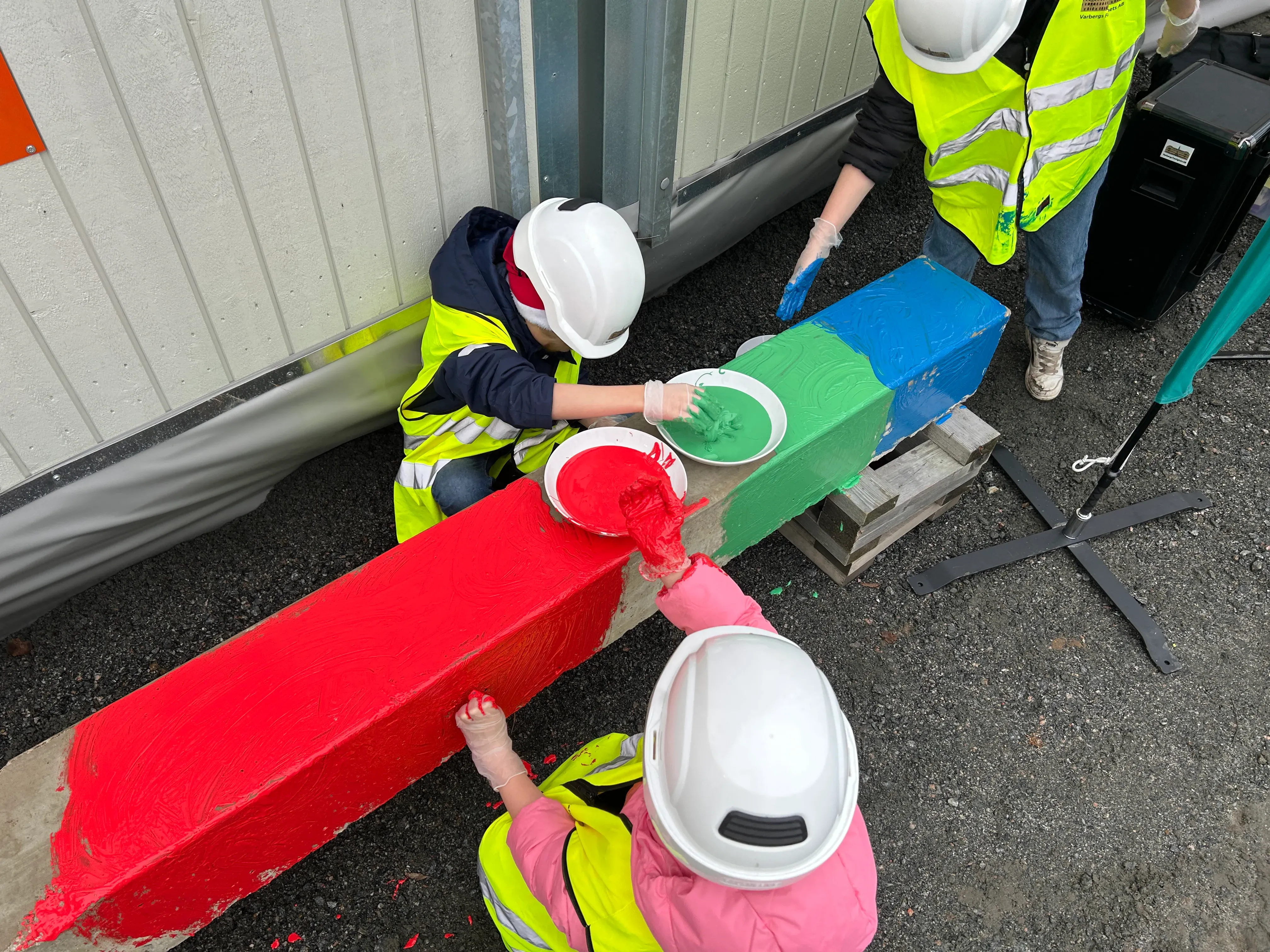 Barn målar betongplint vid spadtaget av nya Tångabergsskolan